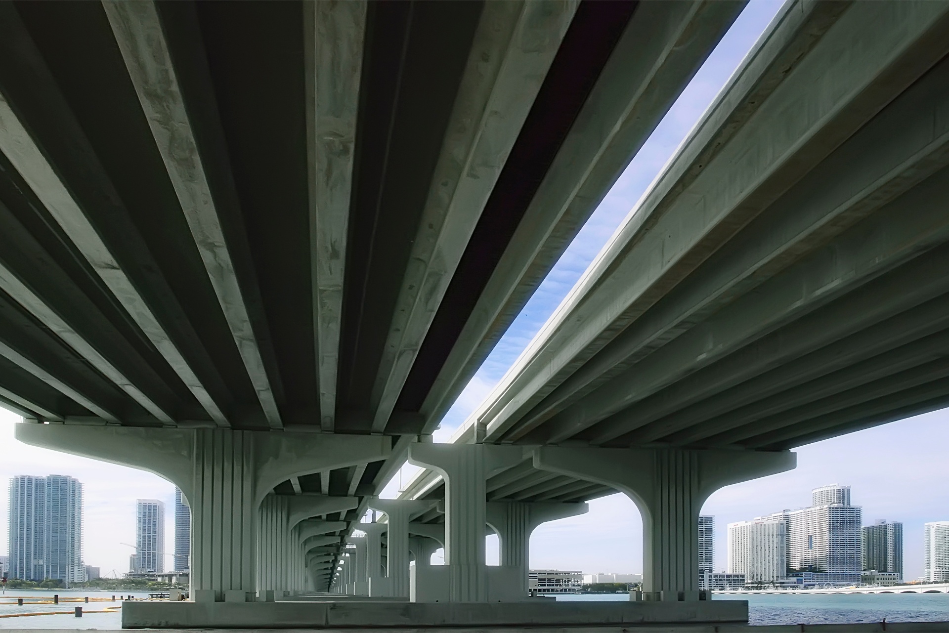 View beneath a concrete viaduct showing structural ribs and piers
